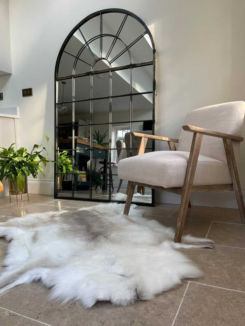 Light tone reindeer hide on floor next to a mirror