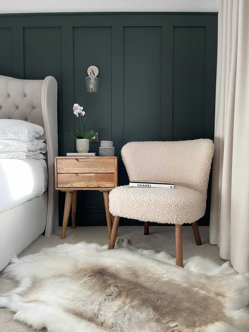 reindeer hide on floor next to a bed