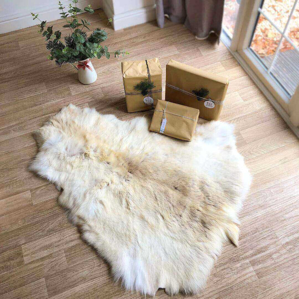 ivory white reindeer hide displayed on wooden floor