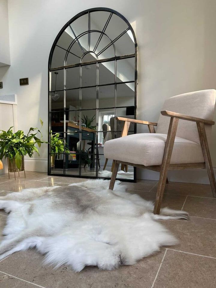 Light tone reindeer hide on floor next to a mirror