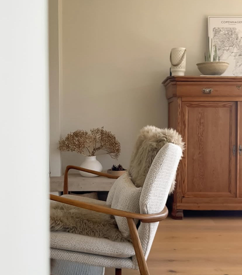 Nestled corner of a room with a wooden cabinet, decorative items, and a chair.