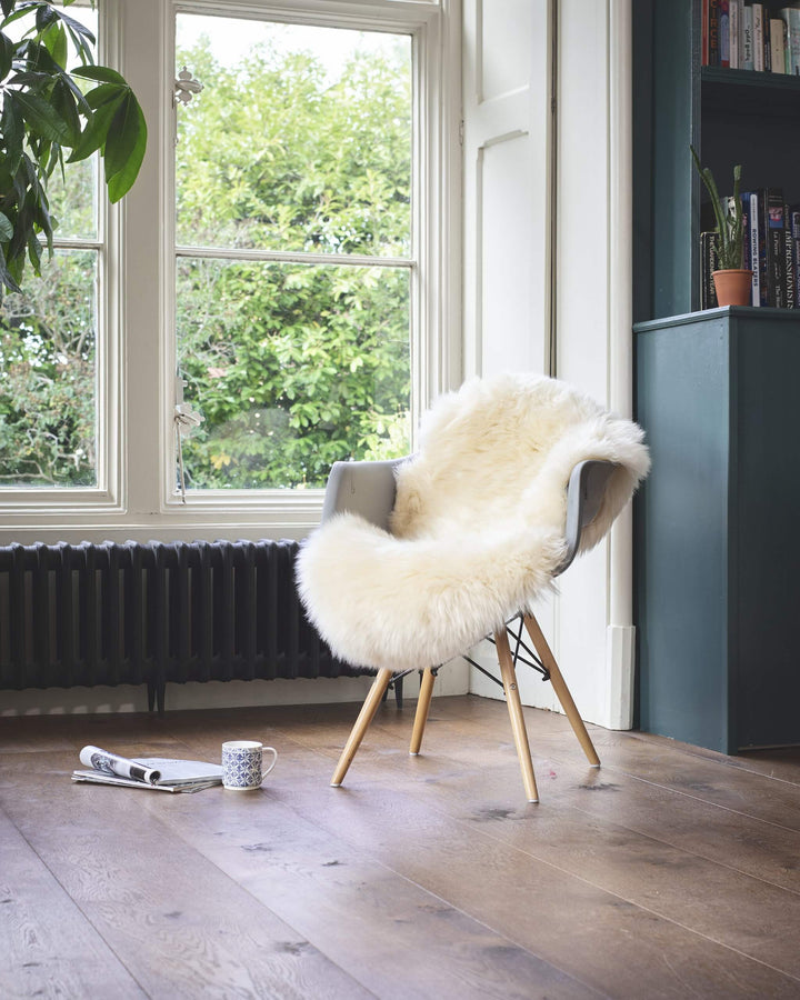 white sheepskin on a chair on a wooden floor 