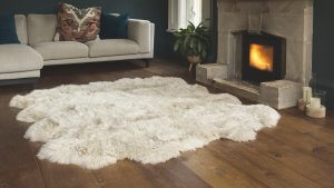 oyster fur rug on a wooden floor in a living room with a fireplace.