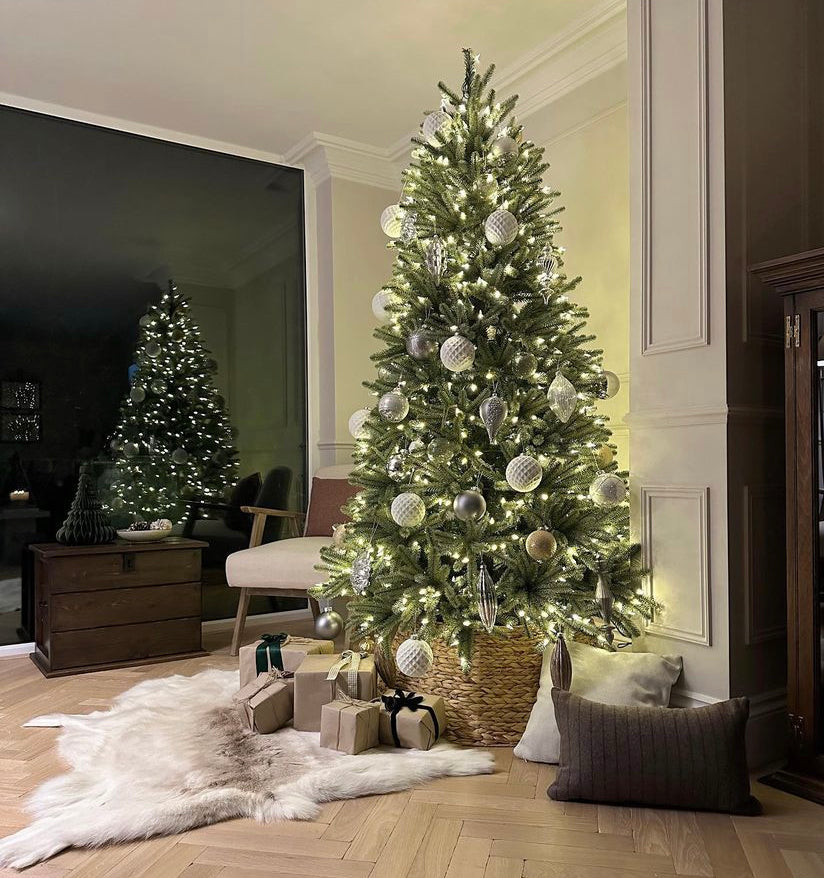 Decorated Christmas tree in a living room with lights and ornaments.