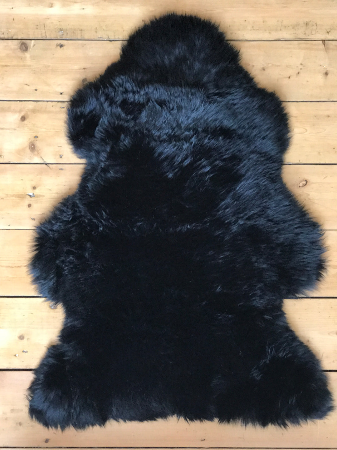 black sheepskin on wooden floor 