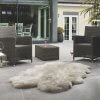 Faux fur rug on a wooden floor with a chair and table in the background