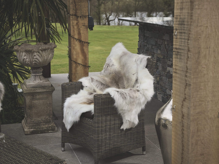 reindeer hide draped on chair outside in a bar area 